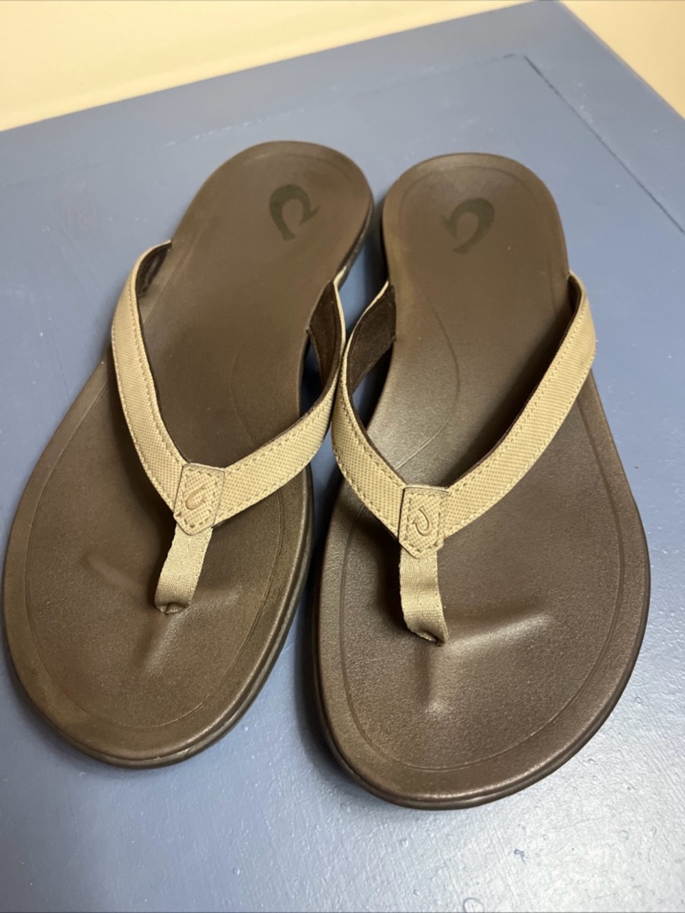 OluKai Ho'opio Hui Flip-Flops in a dark brown and light tan colorway  Size W8